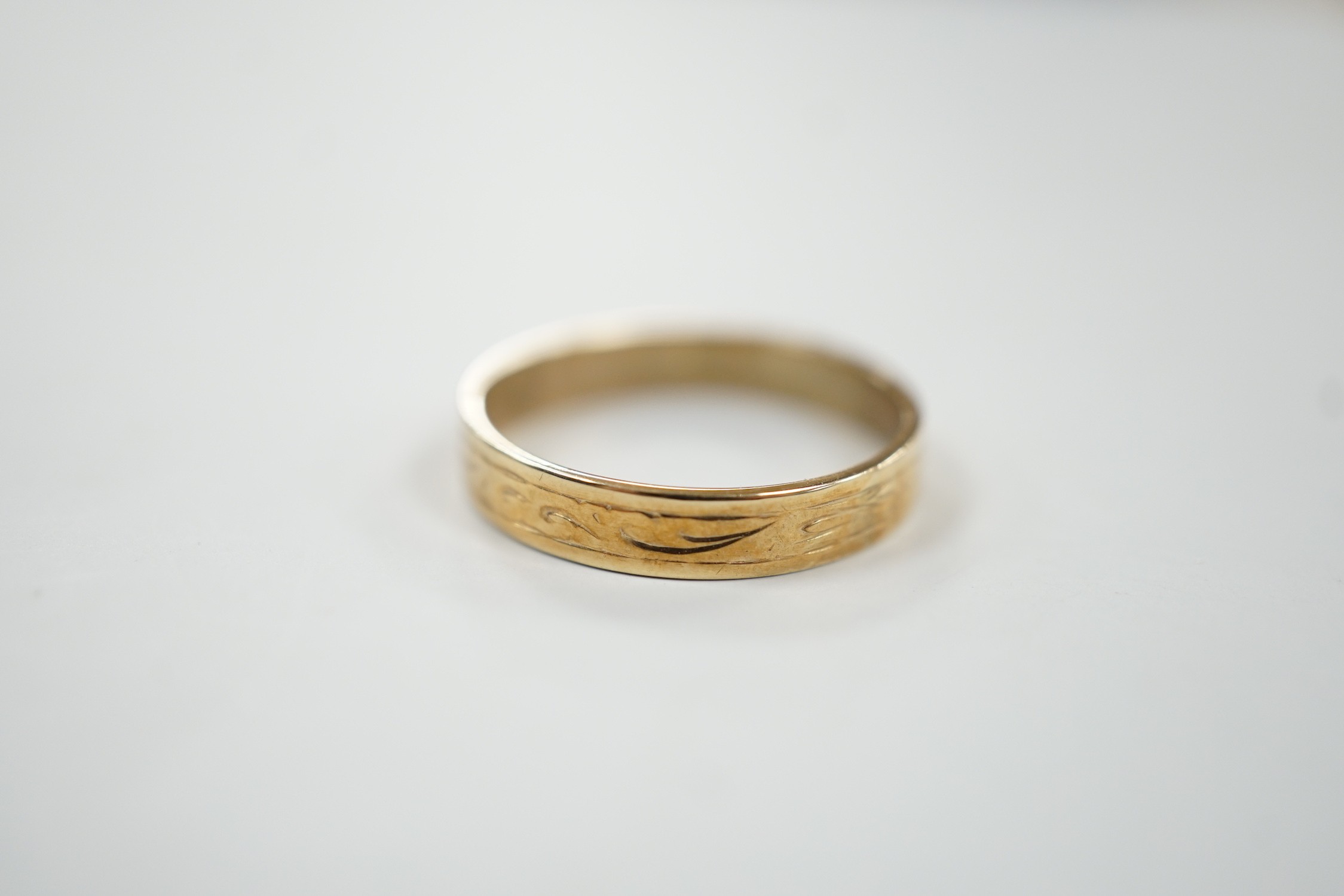 An engraved 9ct gold wedding band, size P, 2.1 grams.